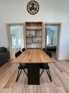 a dining room table with chairs and a clock on the wall at Ferienwohnung "Moseltraum" Ensch in Ensch