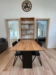 a dining room table with chairs and a clock on the wall at Ferienwohnung 'Moseltraum' in Ensch +12 photos
