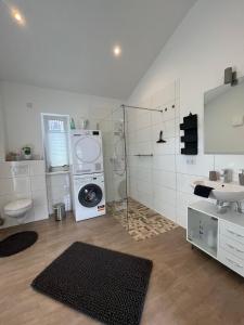 een badkamer met een wasmachine en een wastafel bij Ferienwohnung "Moseltraum" Ensch in Ensch