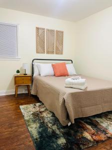 a bedroom with a bed with an orange pillow and a rug at Newly renovated charming home with parking in Fort Washington