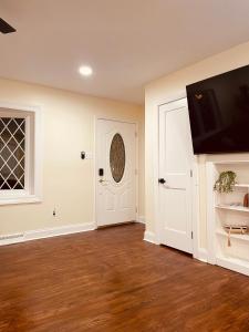 an empty room with a white door and a television at Newly renovated charming home with parking in Fort Washington