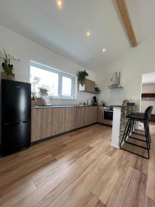 eine Küche mit einem schwarzen Kühlschrank und Holzböden in der Unterkunft Ferienwohnung "Moseltraum" Ensch in Ensch