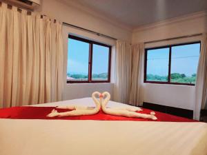 duas pessoas deitadas numa cama com os pés para cima em Kep Villa Hill Guest House 1 em Kep