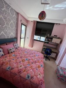 - une chambre avec un lit rose et un bureau dans l'établissement Tajhiz alliance darna, à Kenitra