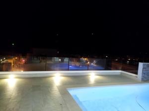 a swimming pool on a roof at night at Duplex penthouse with swimming pool in Xgħajra