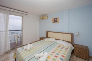 a bedroom with a bed and a large window at El Greco hotel by Estia in Benitses