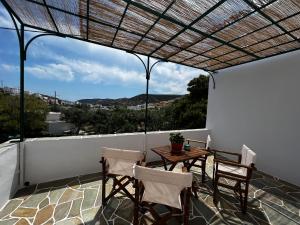 patio con mesa y sillas en el balcón en Sifnos Valley, en Faros