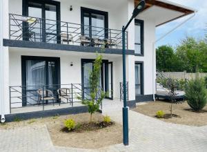 a white house with black windows and a light pole at Apartment, Центр Отдыха Atlantis, Сары-Ой, 1-й этаж in Chon-Sary-Oy +22 photos