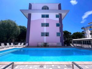 un edificio con piscina di fronte a un edificio di Residence Regent Beach a Bibione