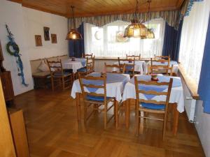 une salle à manger avec des tables et des chaises ainsi qu'une fenêtre dans l'établissement Pension Haus Anne, à Bodenmais