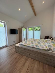 1 dormitorio con 1 cama, TV y ventanas en Ferienwohnung "Moseltraum" Ensch, en Ensch