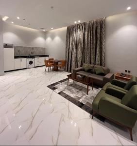 a living room with two couches and a kitchen at نمار هوم للاجنحة المخدومة -طويق in Riyadh