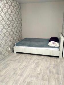 um quarto com uma cama e piso em madeira em Подобово квартира в центрі міста em Konotop