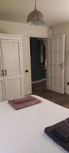 1 dormitorio con 2 puertas blancas y lámpara de araña en Alloggio Turistico Dakota, en Manziana