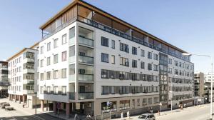 a large white building on a city street at Beautiful Modern City Apartment in Kuopio