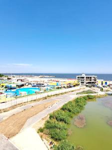a view of a resort with a pool and the ocean at Apartamente Vista Lago e Mare in Eforie Nord