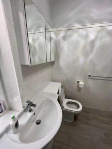 ein weißes Bad mit einem Waschbecken und einem WC in der Unterkunft Anchorage, a lovely 2nd floor one bedroom apartment with fabulous seaviews in Largs