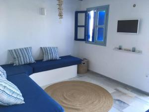 - un salon avec un canapé bleu et une fenêtre dans l'établissement Studio Naxos Orkos plage, à Naxos Chora