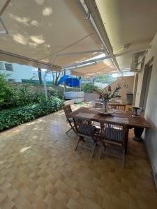a patio with a wooden table and chairs at Casa Roberta con favolosa terrazza privata in Caorle