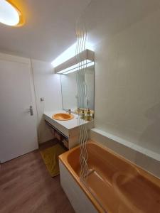 een badkamer met een bad, een wastafel en een spiegel bij La Pause Marine in Le Havre