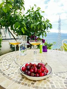a plate of cherries on a table with wine glasses at Rezidenca Oliva in Vlorë