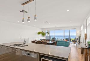 a kitchen and dining room with a view of the ocean at Ocean At Seaford- Beachfront Luxury-Free Wifi in Seaford