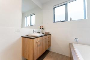 a bathroom with a sink and a bath tub at Ocean At Seaford- Beachfront Luxury-Free Wifi in Seaford +34 photos