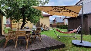 a patio with a table and chairs and an umbrella at Domek babci Marysi in Krasnobród