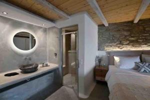 bagno con lavandino, letto e specchio di Paraga Scorpios area Villa2 by CalypsoSunsetVillas a Paradise Beach