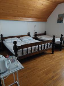 two beds in a room with a wooden ceiling at Turistična kmetija Žerovc in Bled