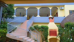 a house with a staircase in front of it at Chez Sabine in Abomey