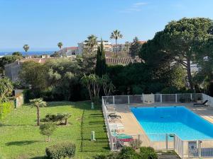 a large swimming pool in a yard with trees at Grand Studio proche mer avec piscine. in Antibes