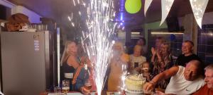 a group of people standing around a table with a cake at California Apart Otel in Oludeniz