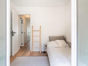 a small bedroom with a bed and a ladder at Zilverzand 202 new construction located on the beach in Koksijde