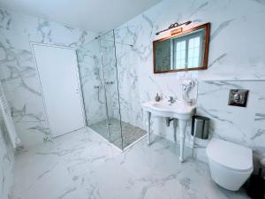 a white bathroom with a shower and a sink at Château de Moliens in Moliens +13 photos
