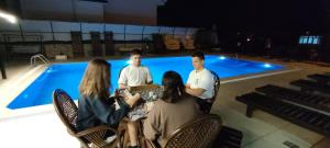 a group of people sitting by a swimming pool at California Apart Otel in Oludeniz