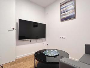 a living room with a flat screen tv on a wall at Hostel Sacromonte in Madrid
