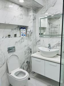 a white bathroom with a toilet and a sink at AURA in Kutaisi +29 photos