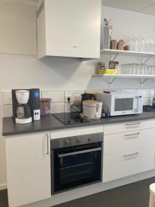 een keuken met witte kasten en een magnetron bij Morlanda B&B in Ellös