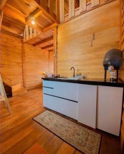 una cocina con fregadero en una cabaña de madera en CALLA HOMESTAY DIENG, en Diyeng