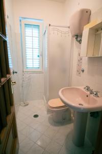 uma casa de banho com um WC, um lavatório e um chuveiro em Villetta nel Verde em Ascea