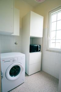uma cozinha com uma máquina de lavar roupa e um micro-ondas em Villetta nel Verde em Ascea