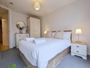 um quarto com uma grande cama branca com lençóis brancos em City Centre Morden 1-bedroom Apt, Free Parking em Liverpool