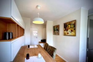 a kitchen with a wooden table in a room at Bright and Modern Home Timisoara in Timişoara