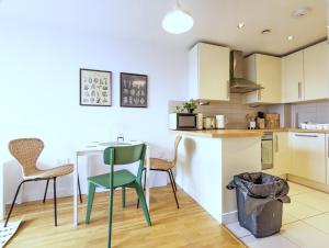 uma cozinha com mesa e cadeiras num quarto em City Centre Morden 1-bedroom Apt, Free Parking em Liverpool
