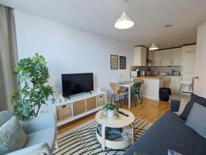 uma sala de estar com um sofá, uma televisão e uma mesa em City Centre Morden 1-bedroom Apt, Free Parking em Liverpool