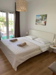 a bedroom with a large white bed with two pillows on it at Apartman Diana in Mali Lošinj