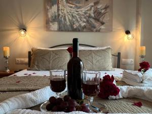 a table with a bottle of wine and glasses on a bed at Marialena's House in Limenas