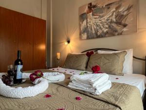 a bed with towels and a bottle of wine on it at Marialena's House in Limenas
