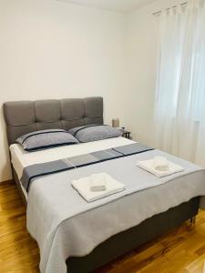 a large bed with two towels on top of it at Apartment Diana Zara parking free in Zadar